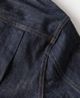 Indigo denim jacket side panel with seam lines and stacked belt-loop stitching
