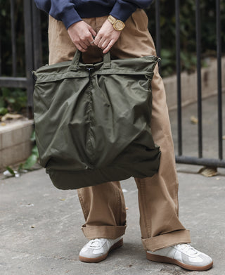 Olive nylon helmet bag with cinch straps and curved top handle