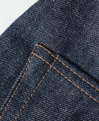 Dark blue denim jeans topstitching along pocket edge with orange-brown thread