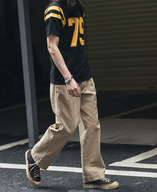 Khaki chino pants on model, relaxed fit with stitched pockets and cuffs