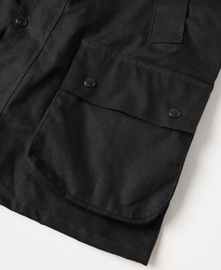 Black waxed chore jacket with front patch pockets and snap buttons
