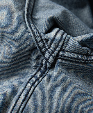 Stonewashed indigo denim work jacket inner collar and zip placket close-up
