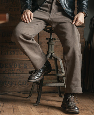 Brown textured stripe pants with a relaxed fit and flat front, worn with lace-up boots