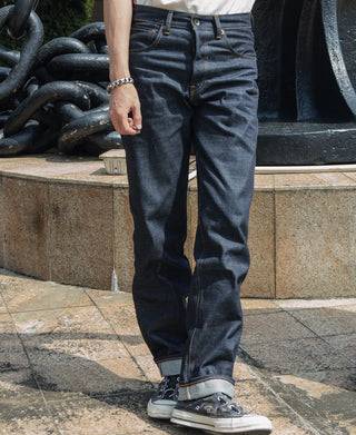 Indigo selvedge denim jeans on model with tapered straight leg and cuffed hem