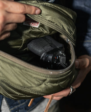 Olive waist bag open interior with dark item compartment and zipper track detail