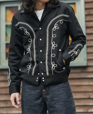Black musician jacket on model, featuring embroidered front panels and snap buttons