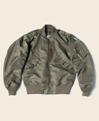 Olive flight jacket front with stand collar, flap pockets, sleeve patch