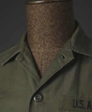Olive utility shirt with button front, pointed collar, and U.S. A patch