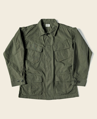 Olive canvas fatigue jacket with button front and flap chest pockets