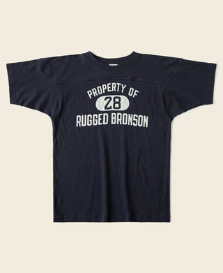 Navy drop-shoulder football t-shirt with “PROPERTY OF 28” graphic and “RUGGED BRONSON” text