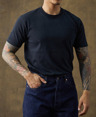 Dark crew-neck cotton T-shirt on model, short sleeves with ribbed collar