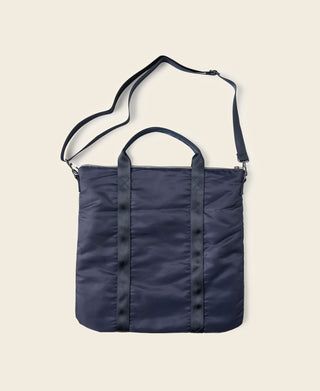 Navy fabric helmet bag with top handle and adjustable shoulder strap