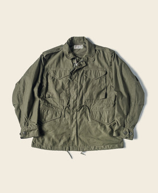 Olive M-1951 field jacket with button front, chest pockets, and flap details
