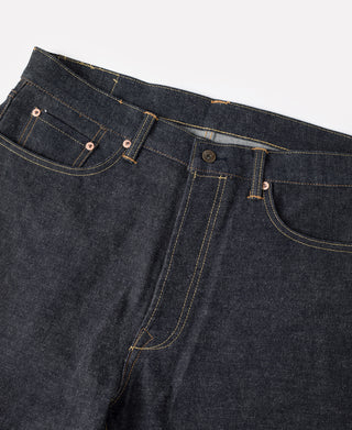 Selvedge denim jeans side view with belt loops, buttoned pockets, and arc seam