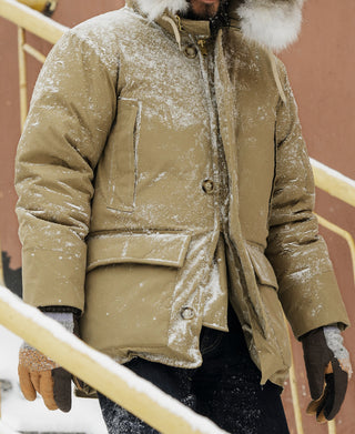 Khaki parka with faux fur-trimmed hood, two front pockets, and long sleeves