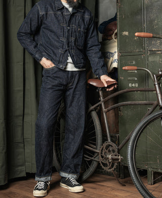 Indigo denim jacket with button front and chest pockets, worn with jeans