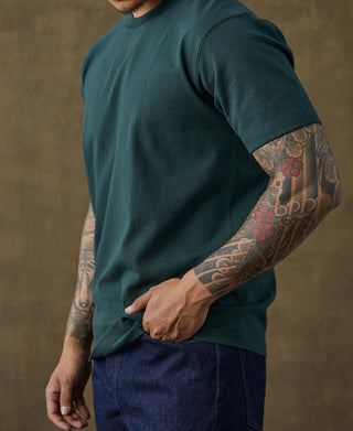 Dark green cotton crew-neck t-shirt on model, angled side view