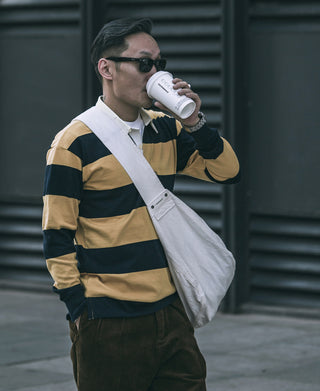 Yellow and navy striped rugby shirt worn by a person, collared neckline visible