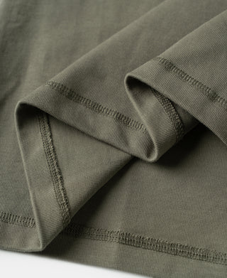Light olive long-sleeve henley shirt cuff with contrast-stitched seams