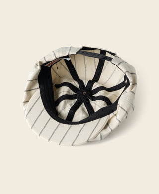 White pinstripe newsboy cap interior with black lining and adjustable strap