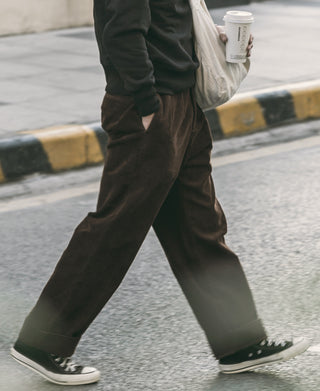 Brown corduroy trousers, straight legs with cuffed hem and visible wale texture