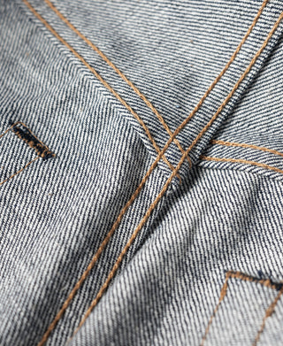 Selvedge denim jeans waistband and belt loop stitching with orange-brown contrast thread