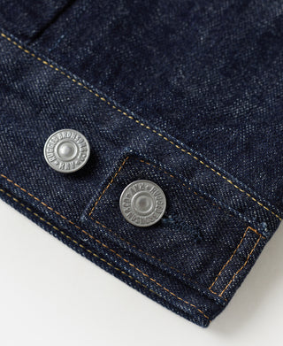 Indigo denim jacket pocket area with two round metal buttons and tan stitching