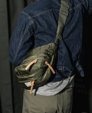 Olive waist bag worn across the body with adjustable strap and front pocket