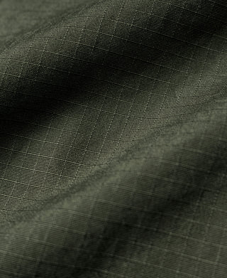 Olive fatigue jacket fabric close-up with fine woven texture
