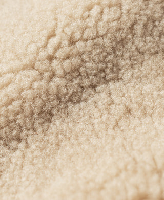 Cream shearling fabric detail with textured surface on the jacket collar