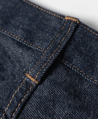 Denim jeans with button-fly front and tan bar-tack reinforcement stitching