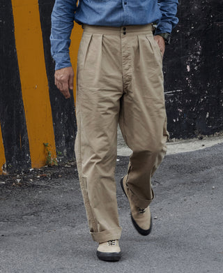 Khaki combat pants on model, cuffed ankle length with front button closure