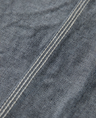 Indigo denim jacket close-up of textured fabric and triple-stitched seam