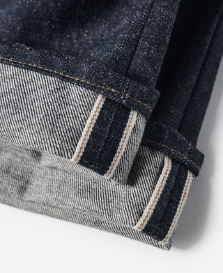 Indigo selvedge denim jeans—hems with visible dark stitching and reinforced cuff
