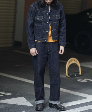 Indigo denim jacket with button front and two chest pockets over a light top