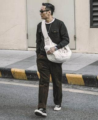 Brown corduroy trousers on model, straight legs with side pockets and cuffed hem
