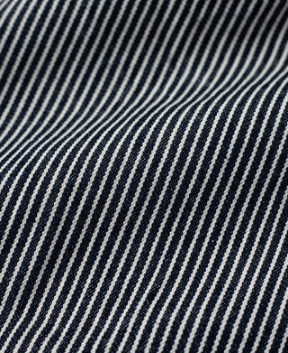 Striped carpenter pants fabric close-up with fine navy and white pinstripes