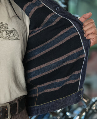 Indigo denim jacket with plaid blanket lining in navy, brown, and tan stripes