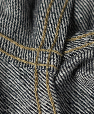 Indigo selvedge denim jacket stitching close-up with contrast yellow seam lines