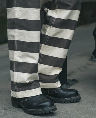 Wide striped prisoner pants on feet, wide-leg white and black stripes with black lace-up boots.