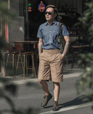 Blue chambray work shirt worn, short sleeves, button front, chest pockets