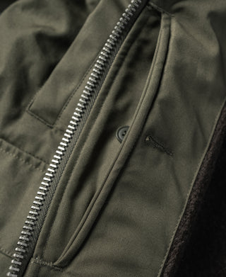Olive jacket zip opening with internal button tab and seam details