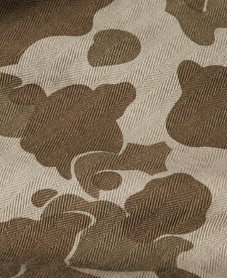 Camouflage cotton pants fabric close-up, herringbone weave pattern in dark and light tan.