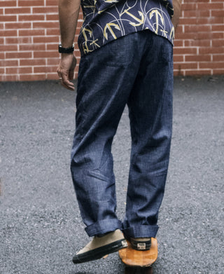 Indigo chambray double-pleated pants worn, back view with cuffed hem
