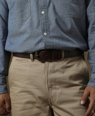 Tan chino trousers with belt loops, front slash pocket, and center seam