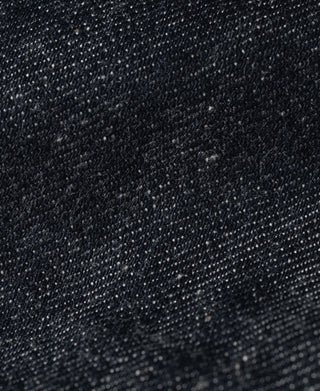 Indigo denim fabric close-up showing tight weave texture and speckled pattern