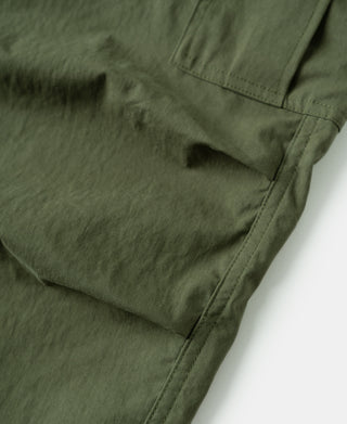 Olive shell trousers with pocket opening and curved hem seam detail