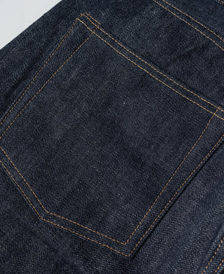 Indigo denim front pocket with reinforced stitching and orange topstitch lines