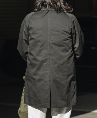 Black all-weather trench coat, back view with center seam and hood