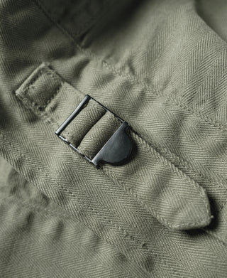 Olive fatigue jacket fabric tab with metal buckle and stitched strap end
